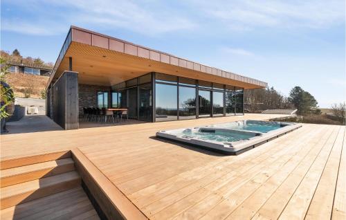 a house with a swimming pool on a wooden deck at Awesome Home In Knebel With Sauna in Knebel