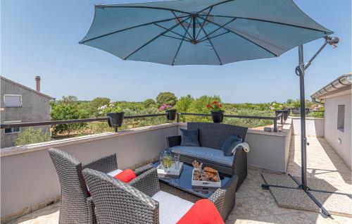 une terrasse avec un parasol bleu sur un balcon dans l'établissement Amazing Home In Oklaj With Wifi, à Oklaj