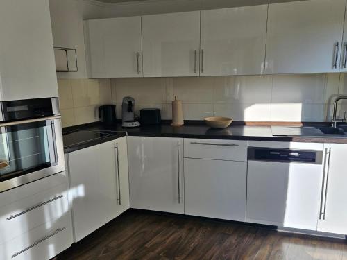 a kitchen with white cabinets and black counter tops at E"STEIN 3 ZKB Balkon in Koblenz