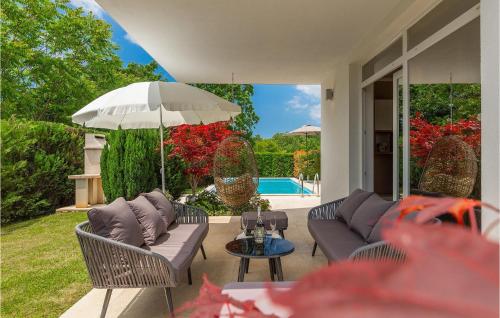 a patio with a couch and an umbrella and a table at Villa Kate in Žminj