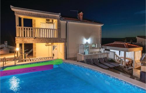 a swimming pool in front of a house at night at Holiday Home Bok in Zaglavice