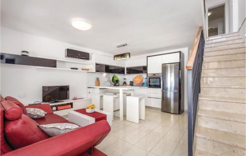 a living room with a red couch and a kitchen at 4 Bedroom Amazing Home In Barbat in Barbat na Rabu