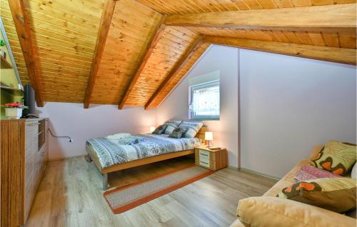 a bedroom with a bed and a couch and wooden ceilings at Amazing Home In Susobreg With Wifi in Jertovec