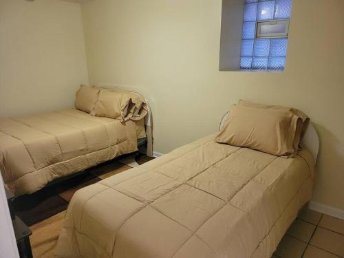 a small room with two beds and a window at Charming 3BD 2BTH Apartment in Chicago