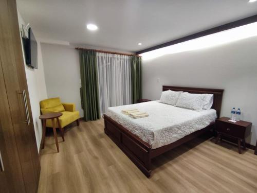 ein Schlafzimmer mit einem Bett und einem gelben Stuhl in der Unterkunft GZ GUEST HOUSE in Cuenca