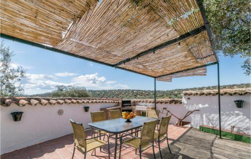 a patio with a table and chairs on a roof at Cozy Home In La Cardenchosa With Wifi in El Alcornocal