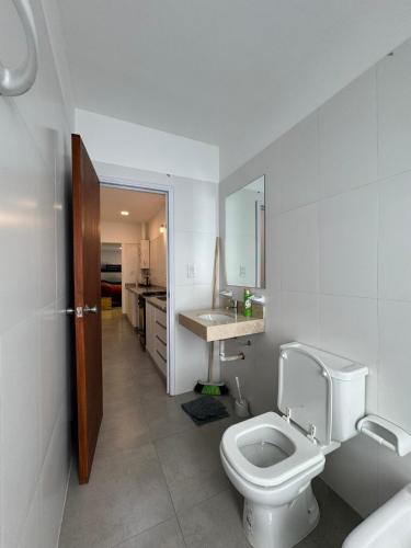 a white bathroom with a toilet and a sink at ALPACA DEPARTAMENTOS in Cafayate