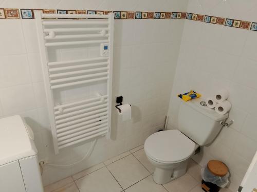 a white bathroom with a toilet and a shower at Le Coin Cozy in Carhaix-Plouguer