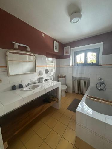 a bathroom with a tub and a sink and a bath tub at Au Clos Caleste in Wellin