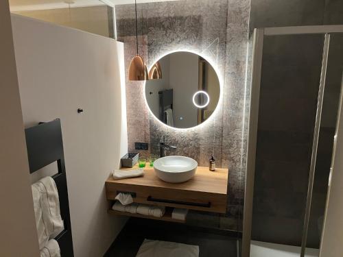a bathroom with a sink and a mirror at Hotel Hecher in Wolfsberg