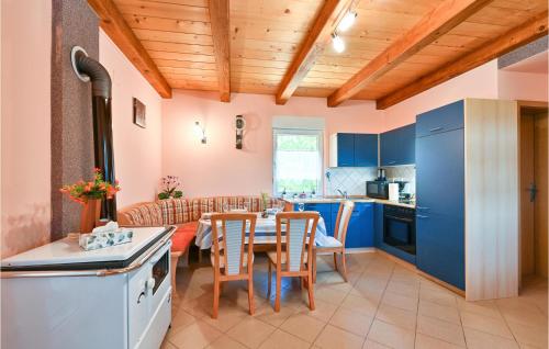 a kitchen and dining room with blue cabinets and a table at Amazing Home In Susobreg With Wifi in Jertovec