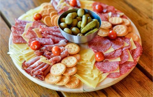 a plate of cheese and crackers and a bowl of dips at Amazing Home In Susobreg With Wifi in Jertovec