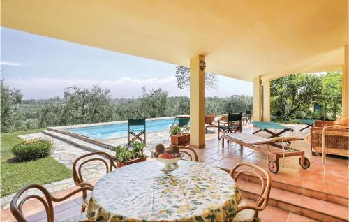 a patio with a table and chairs and a pool at Poggioalvento in Lazzeretto