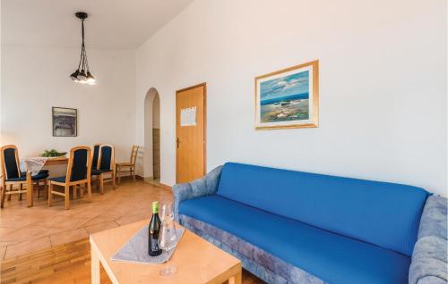 a living room with a blue couch and a table at Lovely Apartment In Njivice in Njivice