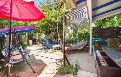 a patio with a hammock and a red umbrella at Holiday Home Sucuraj 06 in Sućuraj