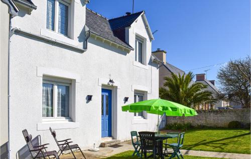 a table with a green umbrella in front of a house at 2 Bedroom Stunning Home In Pleubian in Pleubian