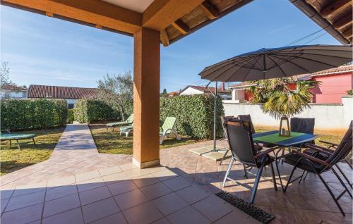 a patio with a table and chairs and an umbrella at 3 Bedroom Lovely Home In Savudrija in Savudrija