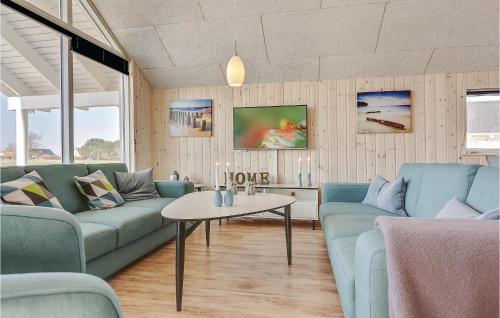 un soggiorno con divani blu e un tavolo di 5 Bedroom Awesome Home In Bogense a Skåstrup