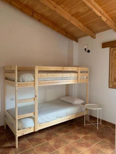 two bunk beds in a room with a table at La Llobatera Casa Rural in Les Coves de Vinroma