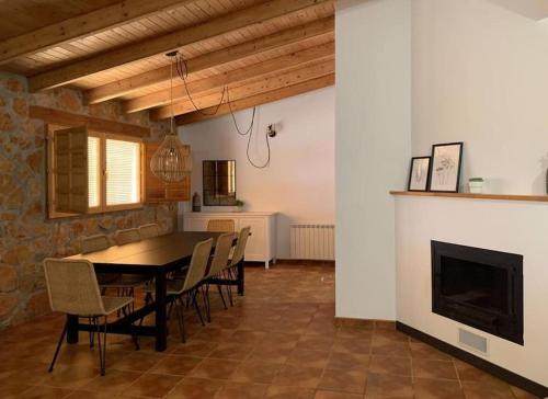 une salle à manger avec une table et des chaises et une cheminée dans l'établissement La Llobatera Casa Rural, à Les Coves de Vinroma