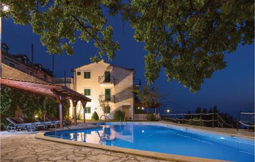 a villa with a swimming pool at night at Lovely Home In Podstrana in Podstrana