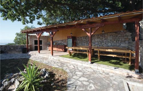 a pavilion with wooden benches in front of a building at Lovely Home In Podstrana in Podstrana