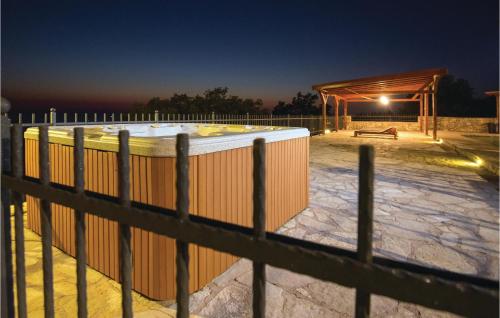 a fence with a hot tub in front of a building at Lovely Home In Podstrana in Podstrana