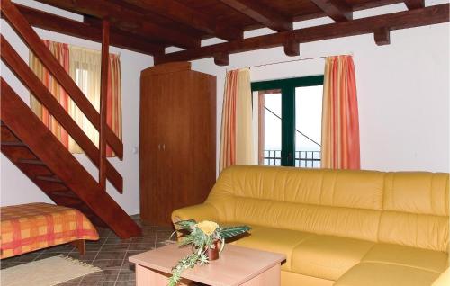 a living room with a yellow couch and a staircase at Lovely Home In Podstrana in Podstrana