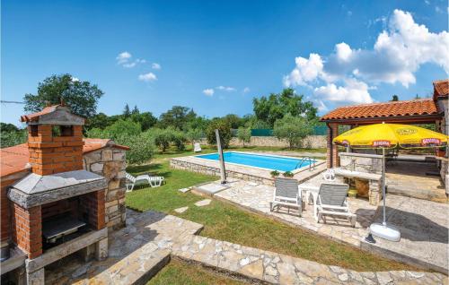 a backyard with a swimming pool and an umbrella at 2 Bedroom Awesome Home In Rovinj in Spanidiga