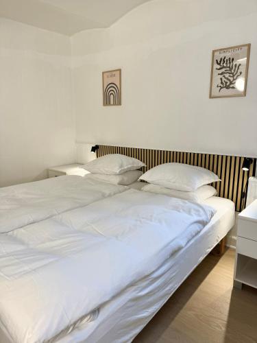two beds in a bedroom with white sheets and pillows at BB Esbjerg in Esbjerg