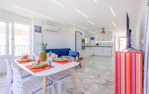 a kitchen and living room with a table and a refrigerator at Cozy Apartment In Guardamar Del Segura in Guardamar del Segura