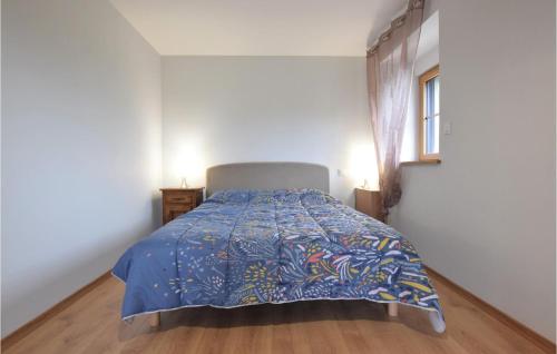 une chambre avec un lit avec une couette bleue dans l'établissement Amazing Home In Fierville-Les-Mines, à Fierville-les-Mines
