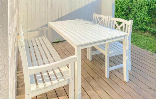 a wooden table and two chairs on a deck at 3 Bedroom Nice Home In Burgsvik in Burgsvik