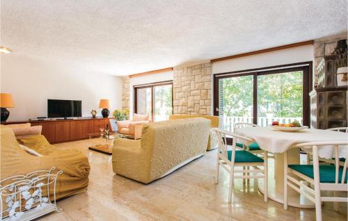 a living room with a couch and a table and chairs at Awesome Home In Malinska With Wifi in Malinska