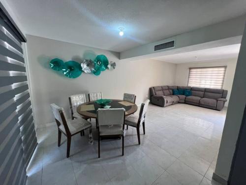 a living room with a table and chairs and a couch at Alojamiento residencial, cerca de TSM in Torreón