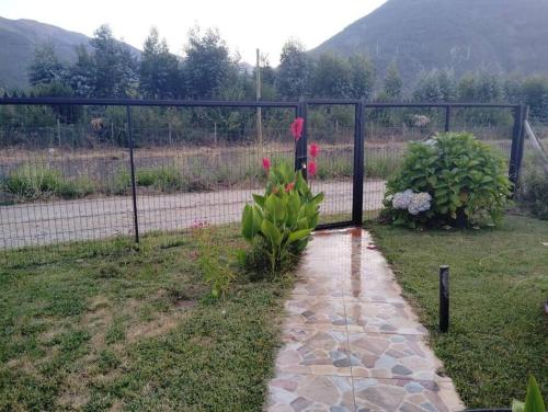 a garden with a fence and some flowers at lindo lugar, cabaña paso nevado in Colbún Alto