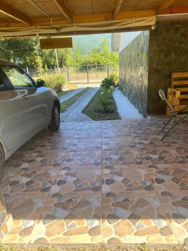 a patio with a car parked on a stone floor at lindo lugar, cabaña paso nevado in Colbún Alto