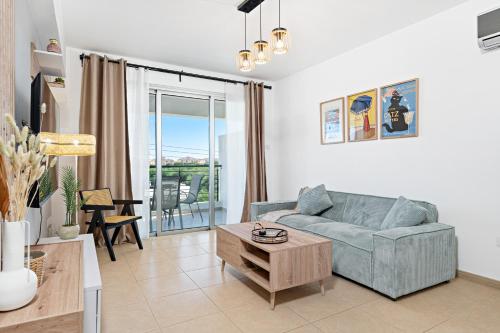 a living room with a couch and a table at Spitaki 2 BDR Apartment with Pool and Close Proximity to Beach in Paralimni