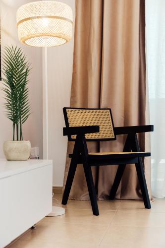 a black chair in a room with a potted plant at Spitaki 2 BDR Apartment with Pool and Close Proximity to Beach in Paralimni