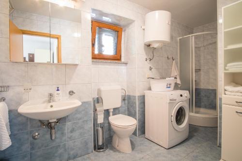 a bathroom with a toilet sink and a washing machine at Villa Vita in Polje