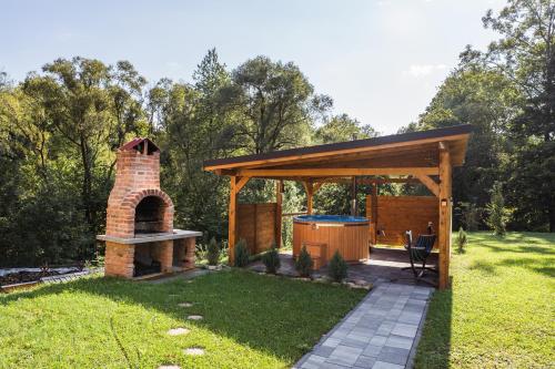 a pavilion with a brick oven in a yard at Niedźwiedzia Dolina in Przybyszów