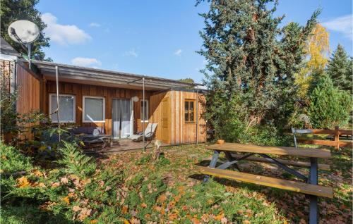 a wooden cabin with a picnic bench in front of it at Lovely Home In Zeulenroda-Triebes in Stelzendorf
