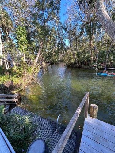 a person is standing on a dock over a river at Main River Retreat hot tub, canoe with trolling motor in Spring Hill