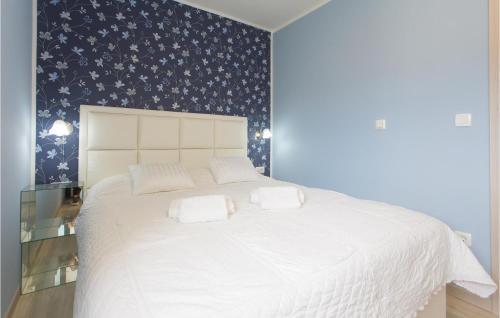 a bedroom with a white bed with a blue patterned wall at 1 Bedroom Amazing Apartment In Podgrade in Slime
