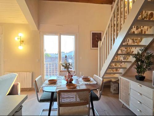 une salle à manger avec une table et des chaises et un escalier dans l'établissement Marmande centre - 4pers, à Marmande