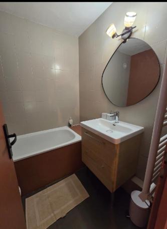 une salle de bain avec un lavabo, une baignoire et un miroir dans l'établissement Marmande centre - 4pers, à Marmande