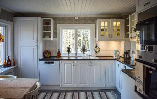 a kitchen with white cabinets and a window at 2 Bedroom Pet Friendly Home In Burseryd in Sjötofta