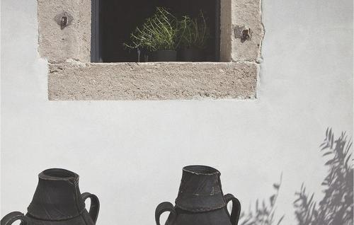 two black vases sitting in front of a window at Villa Petit in Radetići