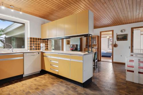 a kitchen with white cabinets and a wooden ceiling at Cozy Holiday Home In Thisted in Thisted
