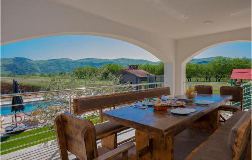 - une salle à manger avec une table et une vue sur les montagnes dans l'établissement Amazing Home In Donji Prolozac, à Donji Proložac